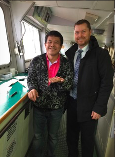 Left, Captain Kennedy on board the Milagro departing Roberts Bank Coal bound for the pilot station. The ships Captain is holding a paper crane.